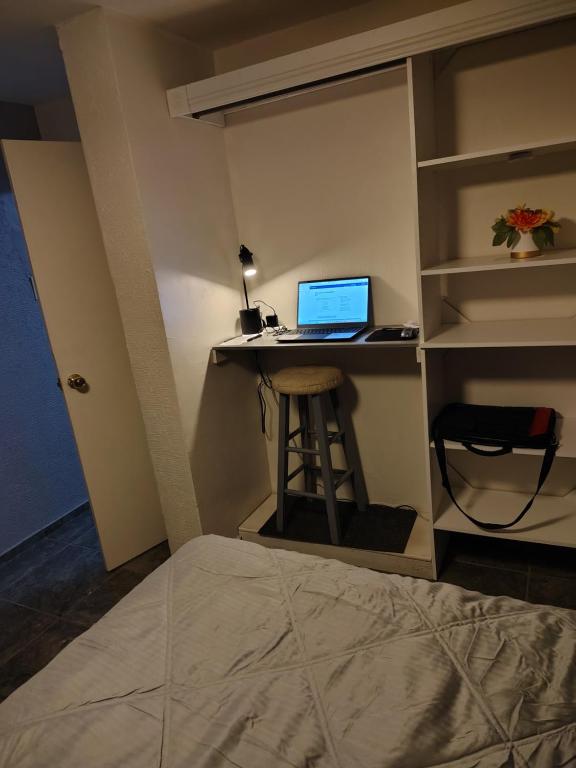 a bedroom with a desk with a laptop computer on it at El Rinconcito in Santa Ana