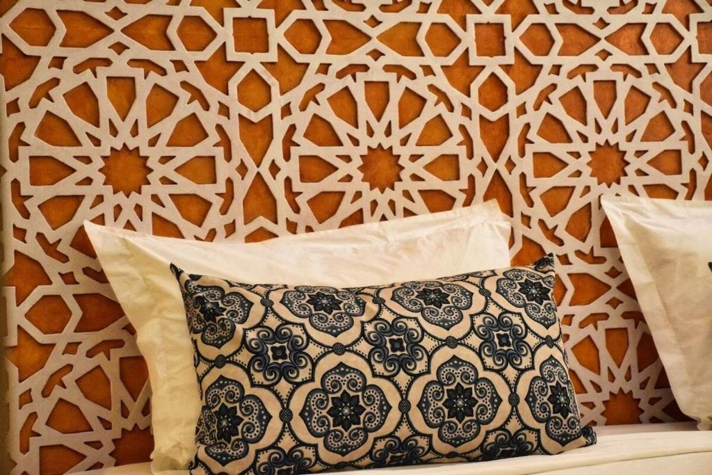 a bed with a pillow in front of a wall at HoneyPath Atlas Retreat in Agadir