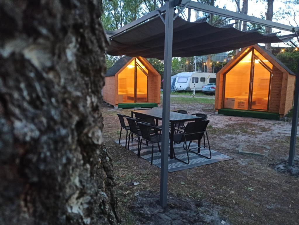 a picnic table and chairs under a canopy with tents at Happy House Hel in Hel
