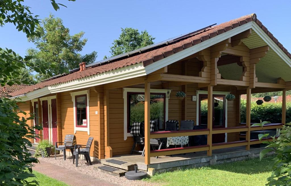 a wooden house with a porch and chairs at Just Relax in Gramsbergen