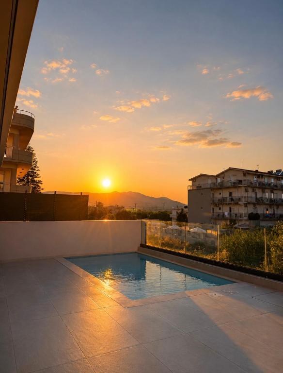 a sunset over a swimming pool on top of a building at Aurelia Luxury House in Amoudara Herakliou