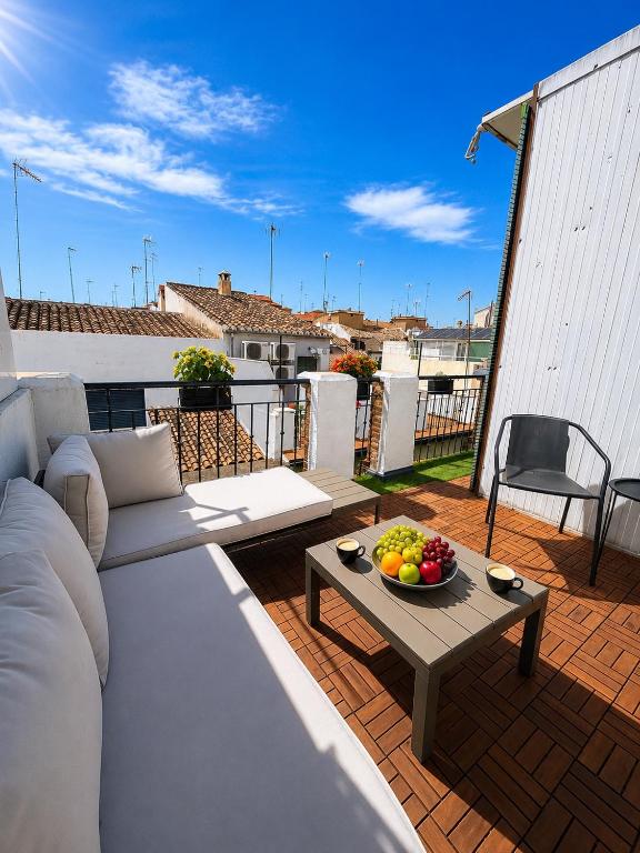 a balcony with a couch and a table with a bowl of fruit at Penthouse San Isidro 3 suites Terraza Privada Parking in Granada