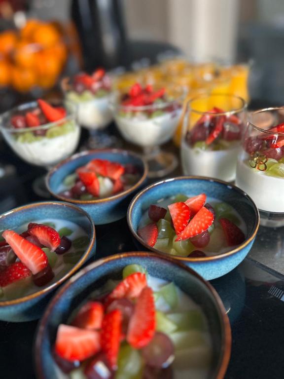 a table topped with bowls of fruit and desserts at B&B Prachtig Allemachtig in Valkenburg