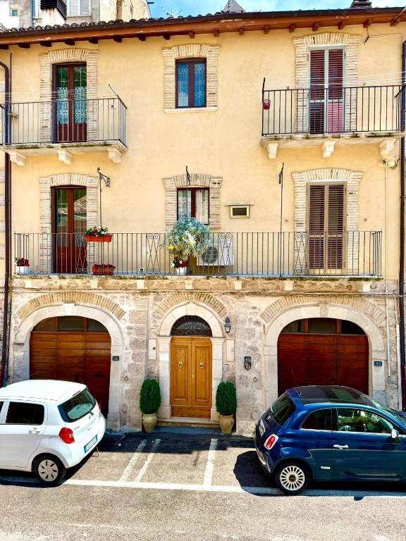 two cars parked in a parking lot in front of a building at Via Roma 40 - apartment in Pacentro