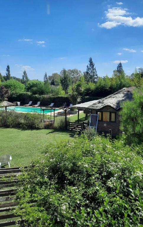 a building with a swimming pool and a house at Casas de Campo Hoja in Chascomús