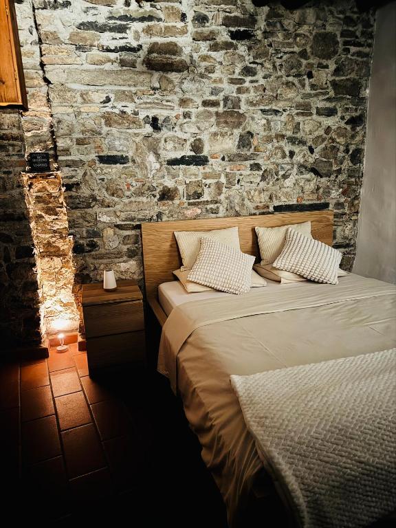 a bedroom with a bed and a brick wall at Dolce Notte - Rustico a Gandria in Lugano