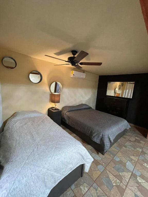 a bedroom with two beds and a ceiling fan at Habitacion G in San Quintín