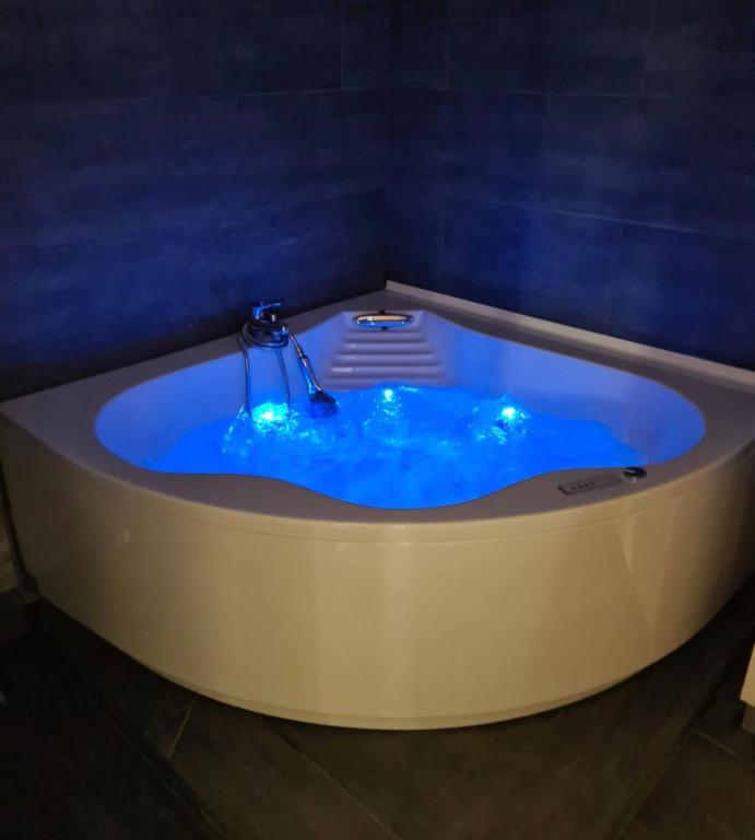 a jacuzzi tub with blue lighting in a room at Appart cosy avec balnéo, balcon, clim à 15 min de la Cité in Carcassonne