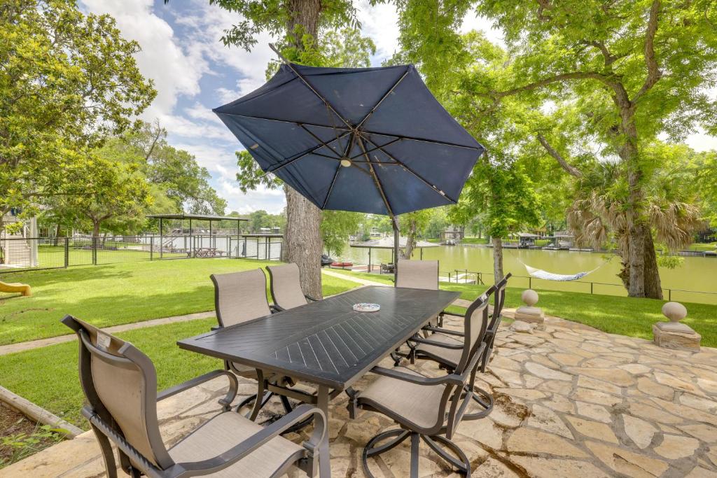 a black table and chairs with an umbrella at Spacious Lake Placid Retreat w/ Gorgeous Views! in Seguin