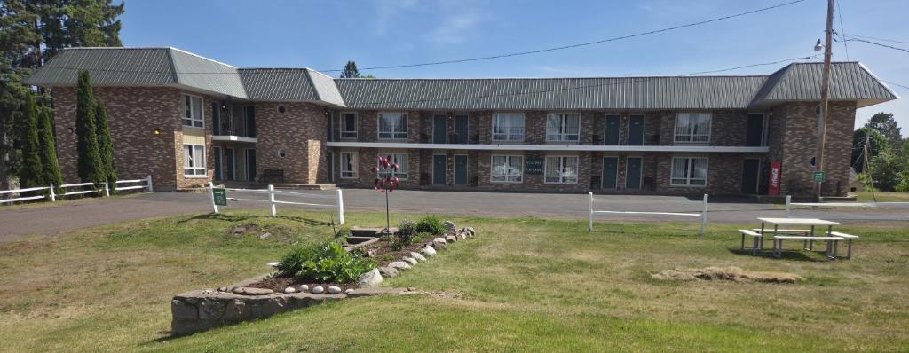 a large brick building with a picnic table in front of it at Budget Host Inn in Ironwood