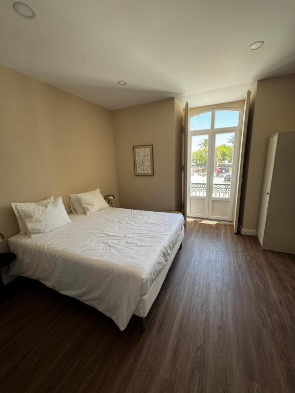 a bedroom with a large bed and a large window at Casa da Praça- Boutique Rooms in Tavira