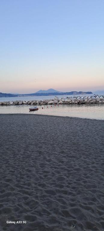 a sandy beach with a view of the ocean at Addor 'e Mare in Bacoli