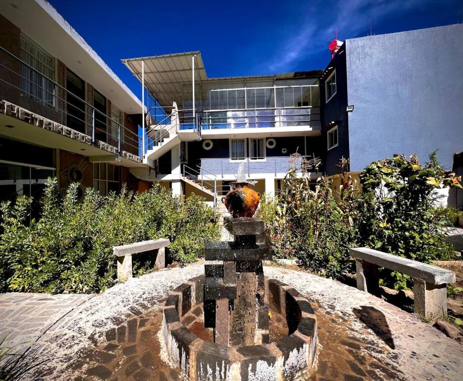 a building with a fountain in front of a building at hotel orkkowasi colca in Coporaque