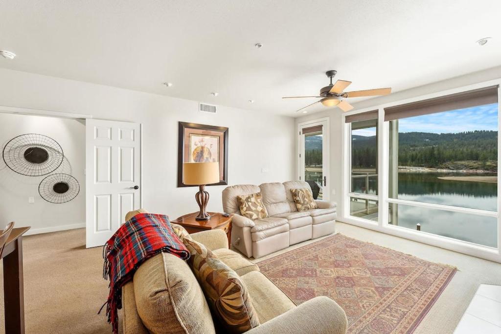 a living room with a couch and a window at Salmon Run Condo - Overlooking the Spokane River in Post Falls