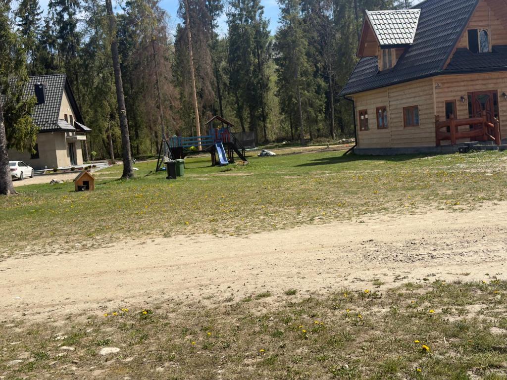 a house with a dirt road in front of a yard at Camping Przy Termach in Bańska Niżna