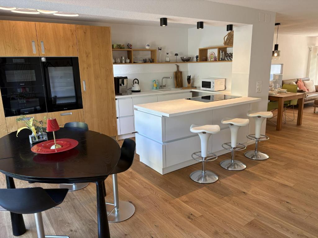a kitchen with a table and chairs and a counter at City Lake & Peaks Thun in Thun