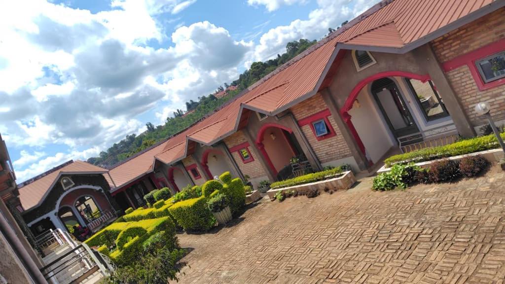 a house with a brick driveway in front of it at Madina Homes in Butare