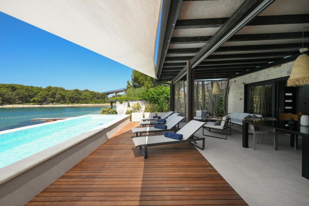 an outdoor pool with lounge chairs and a swimming pool at Luxury Feel Good House by the Sea with the Pool in Ždrelac