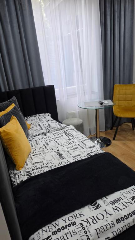 a bedroom with a bed and a table and a window at Anpol 1 idealny dla jednej osoby in Inowrocław