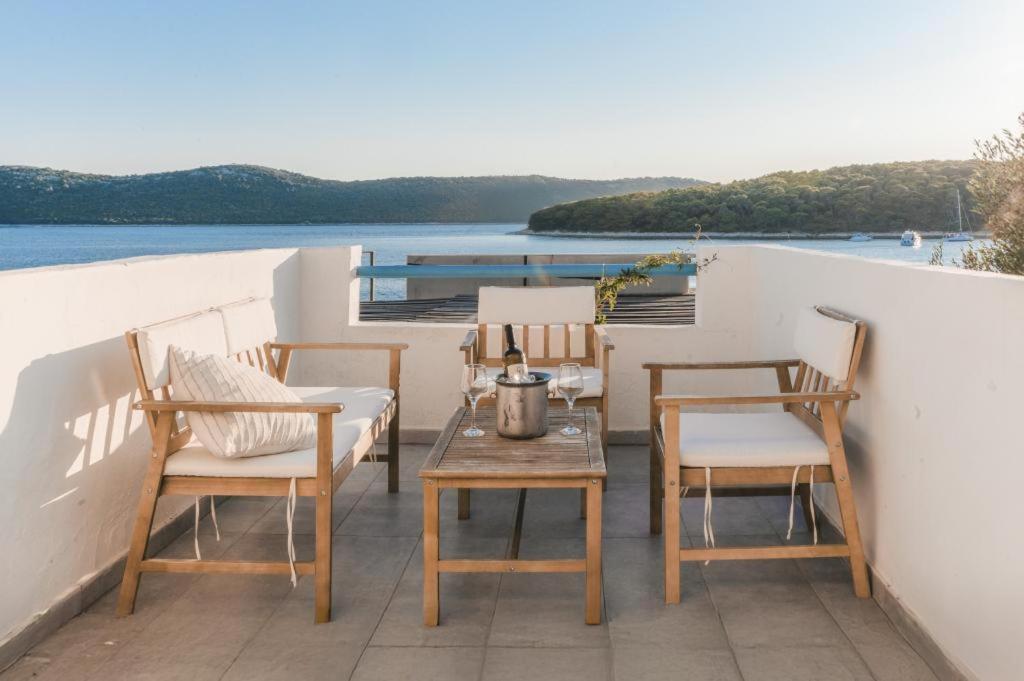 a table and chairs on a balcony with a view of the water at Apartments on island Molat next to the sea - by TA Leut Agency in Brgulje
