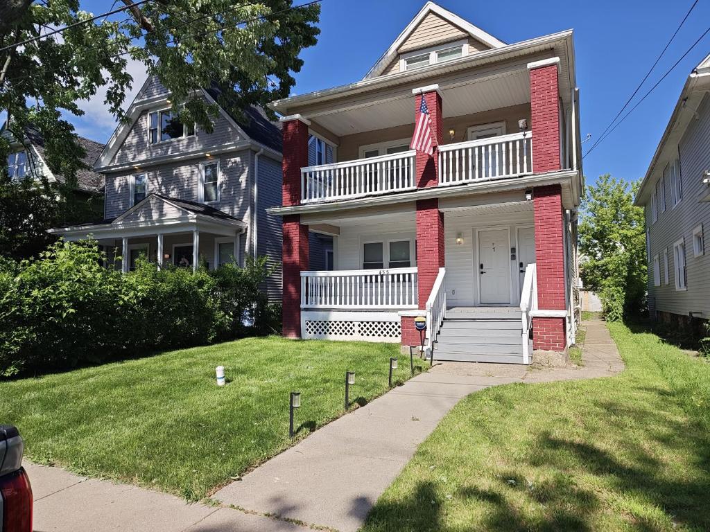 a house with a white door and a yard at Modern Niagara Loft with Private Sunset Balcony Duplex in Niagara Falls