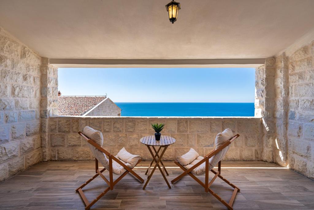 a balcony with a table and chairs and the ocean at Rezevici Horison View Apartment in Reževići