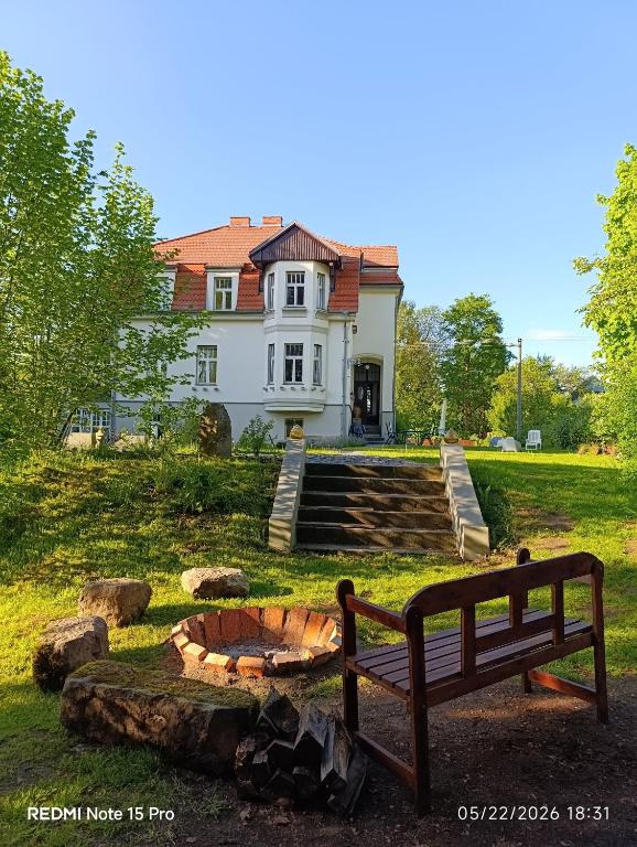a bench sitting in front of a house at Vila Adelaide in Brtníky
