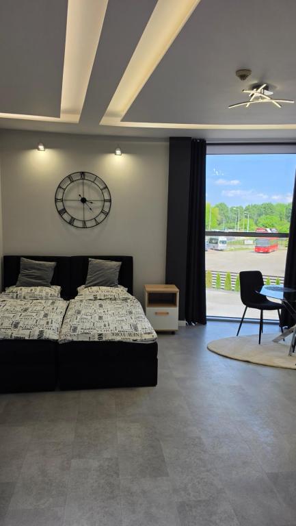 ein Schlafzimmer mit einem Bett und einer Uhr an der Wand in der Unterkunft Anpol Udany Wypoczynek in Inowrocław