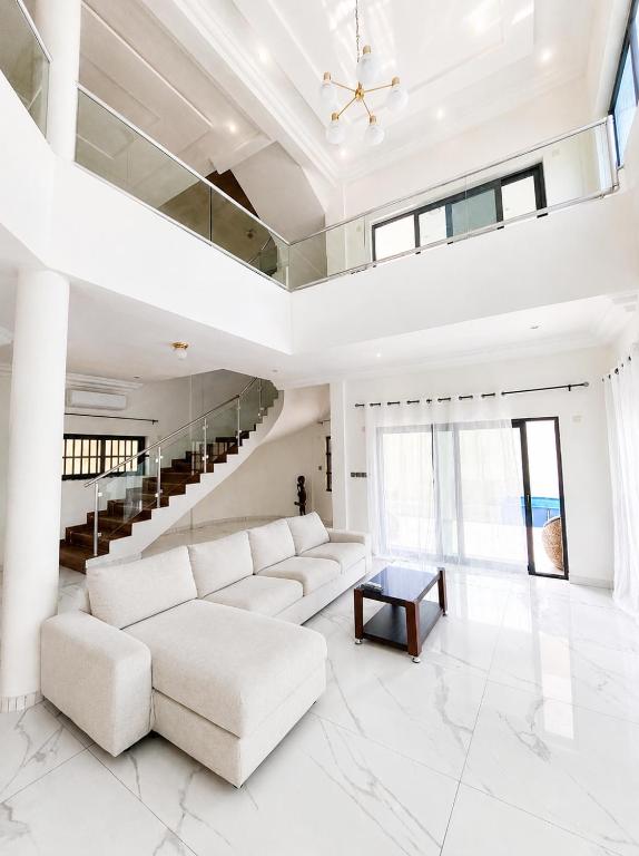 a white living room with a white couch and a table at villa face à la mer in Cotonou