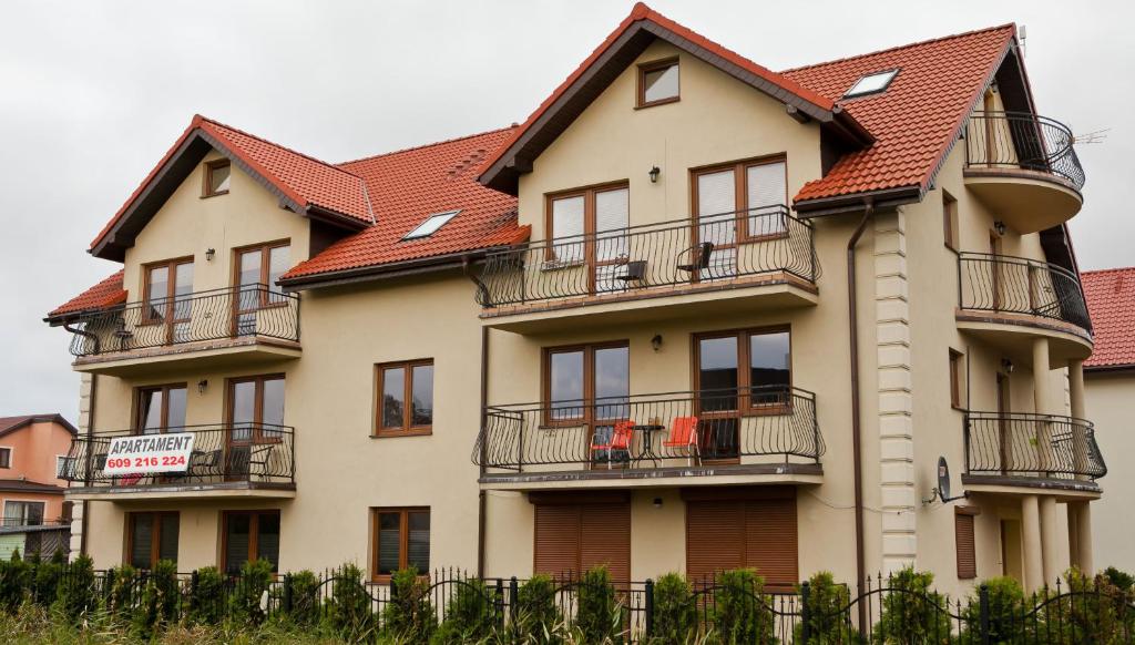 un gran edificio con balcones y techos rojos en Apartamenty by Hanna, en Łeba