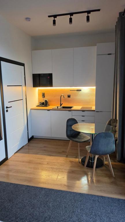 eine Küche mit Tisch, Stühlen und Spüle in der Unterkunft ANPOL komfort in Inowrocław