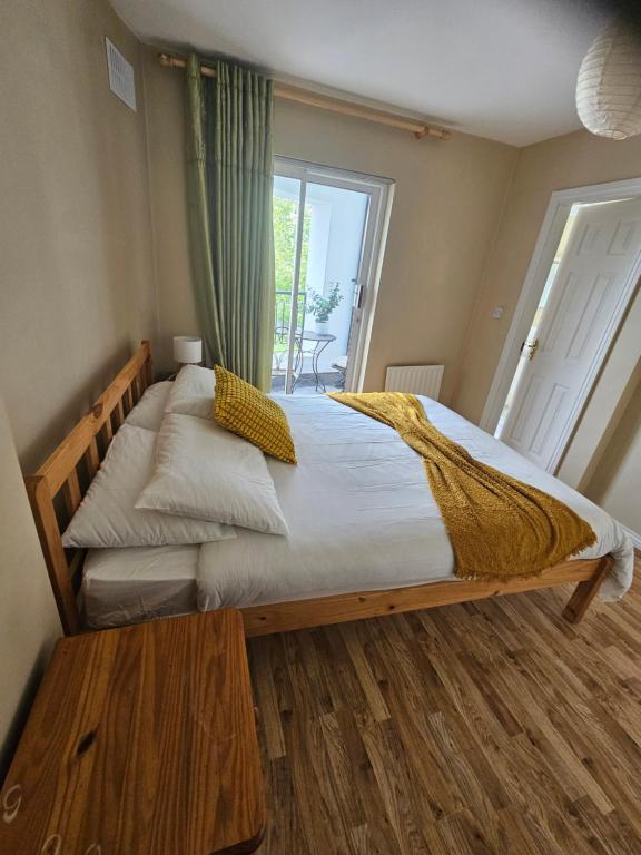 a bedroom with a large wooden bed with a window at The Yellow Bollard in Galway
