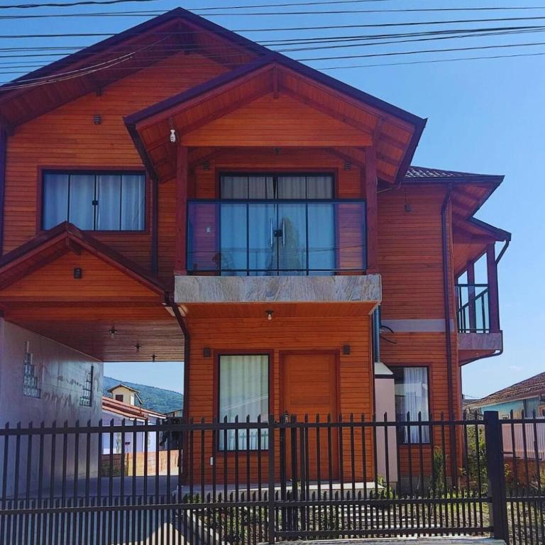a wooden house with a fence in front of it at Urubici Maravilhas da Serra 2 in Urubici