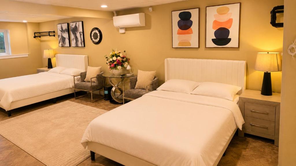 a bedroom with two beds and a table with flowers at Private Two Queen Beds Room Near UPEI & Downtown Cozy Retreat Near Everything in Charlottetown