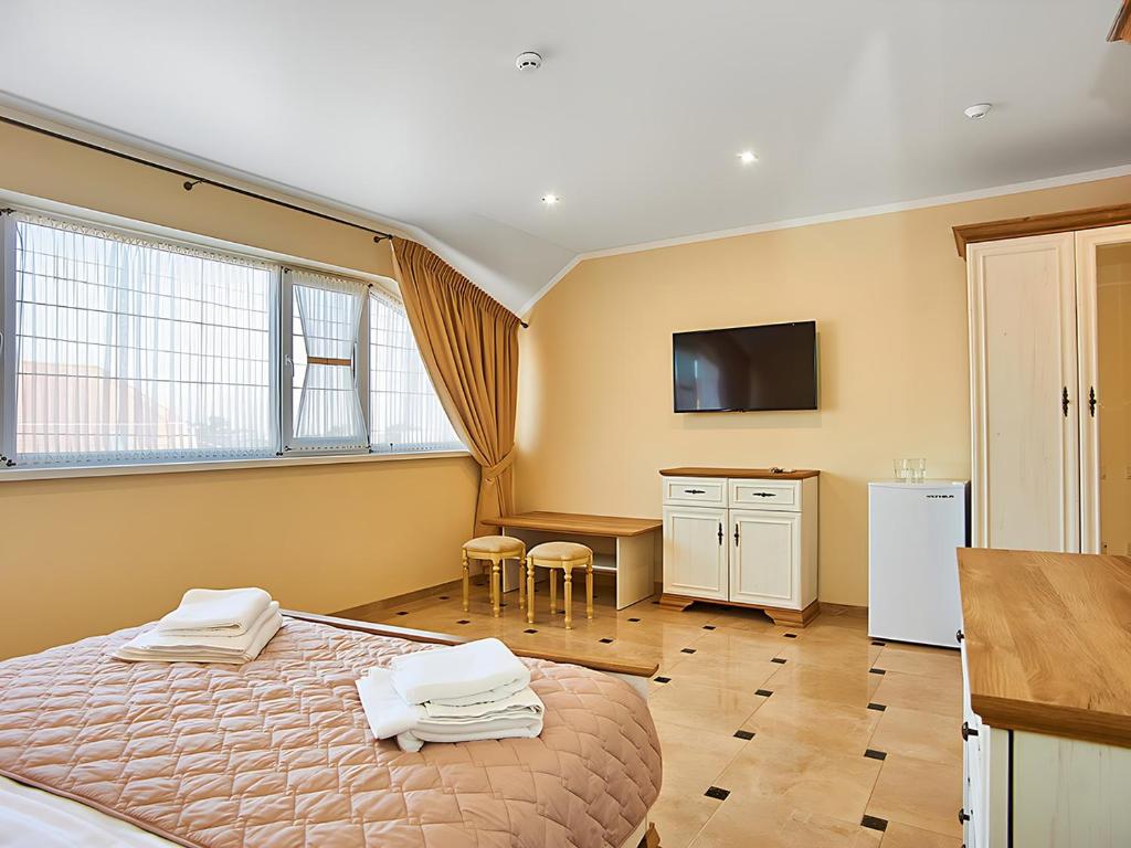 a bedroom with a bed and a desk and a television at Guest house Nikolaevsky in Bilhorod-Dnistrovskyi