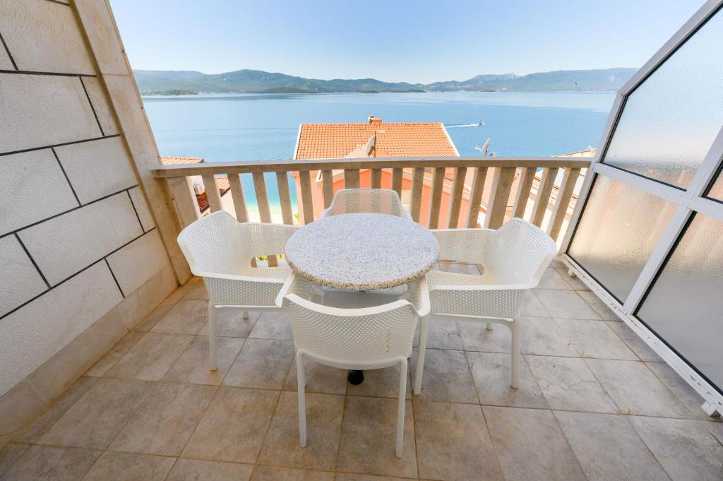 a table and chairs on a balcony with a view of the water at Royal Sea Panorama in Komarna