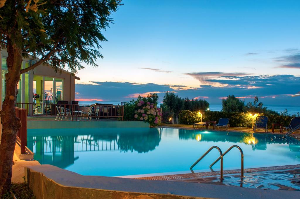 a swimming pool at night with a resort at Samothraki Village Hotel in Palaiopoli