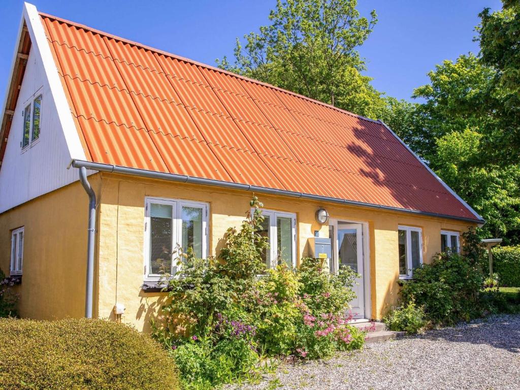 an orange roofed house with an orange roof at Historic Gem in Samsø in Brundby