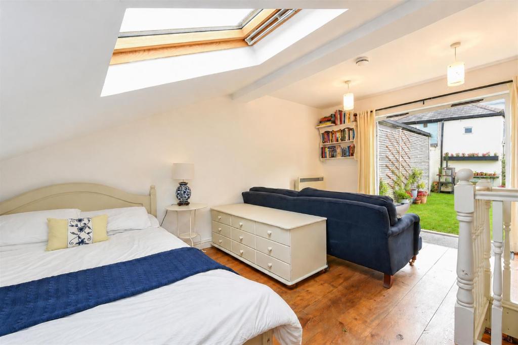 a bedroom with a bed and a couch and a window at Garden room, central Winchester in Winchester