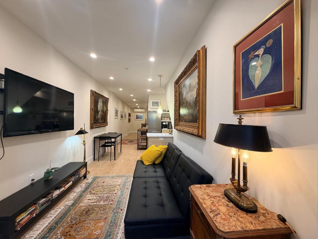 a living room with a black couch and a tv at The Hudson Horizon in West New York