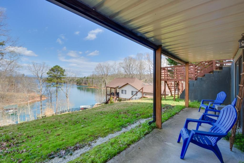 two blue chairs sitting on a porch overlooking a lake at 3-Unit Combo w/ Dock on Lake Keowee - Hike & Fish! in Seneca