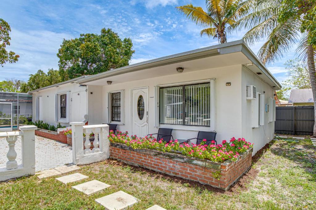 a small white house with flowers in a yard at 4 Mi to Surfside Beach! North Miami Apt in North Miami