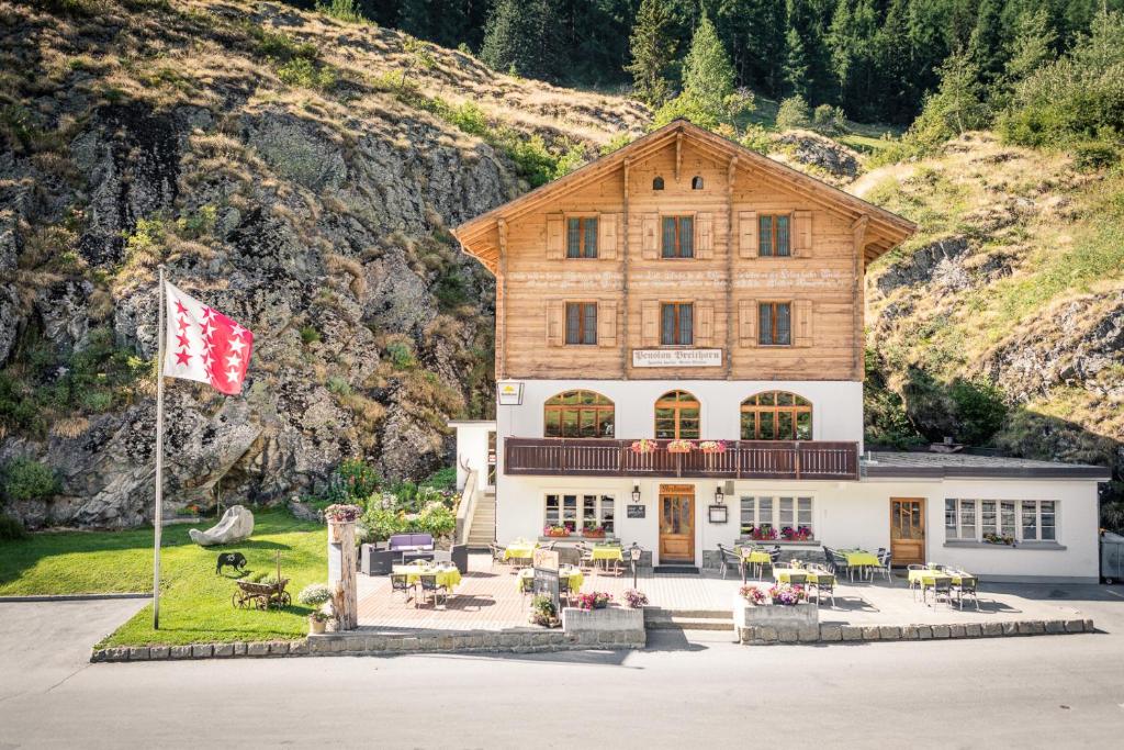 ein großes Gebäude mit einer Flagge davor in der Unterkunft Hotel Breithorn in Blatten im Lötschental