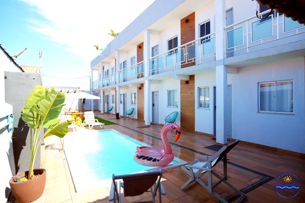 a swimming pool with a pink flamingo on a building at Praia Studios in Vila Velha