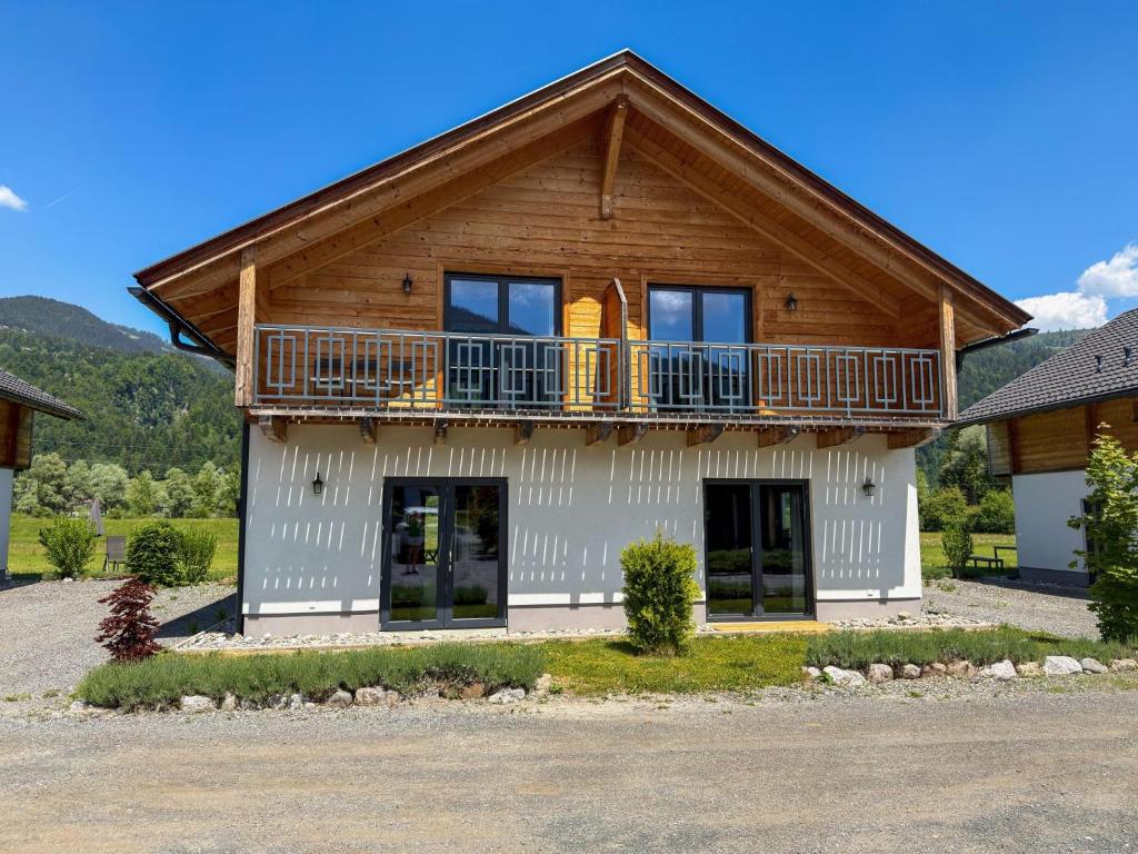 a house with a wooden roof and a balcony at Rattendorf 13B in Rattendorf