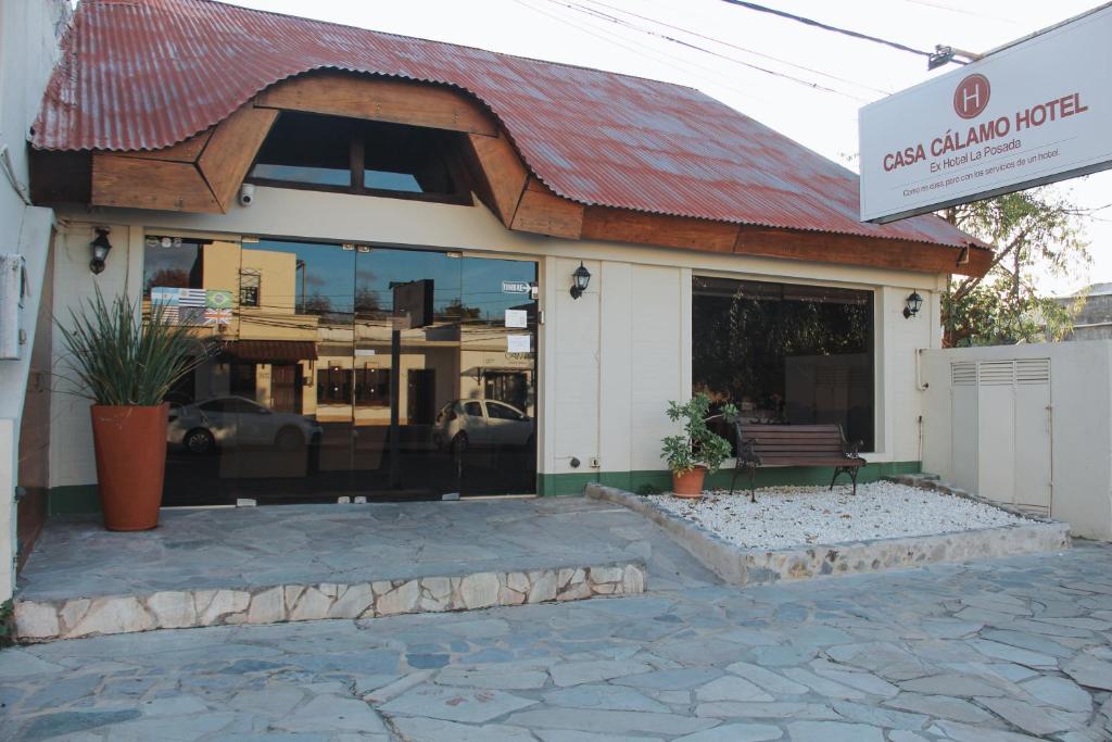 a building with a red roof with a bench in front at Casa Calamo Hotel in Treinta y Tres