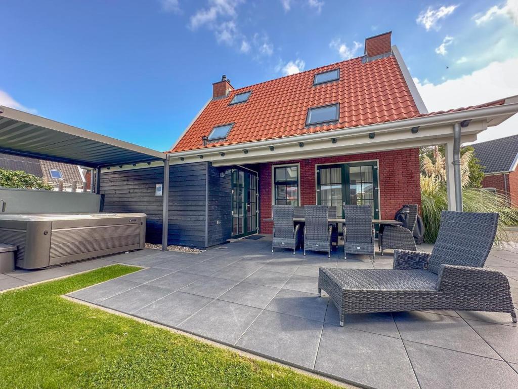 a patio with chairs and a table in front of a house at Sea Quality 83 in Colijnsplaat