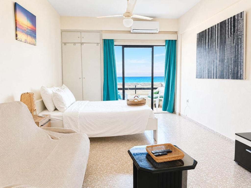 a bedroom with a bed and a living room with a view at The Seafront Pearl in Larnaca