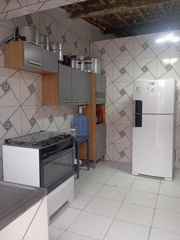 a kitchen with a stove and a refrigerator at Casa simples e aconchegante in Campina Grande