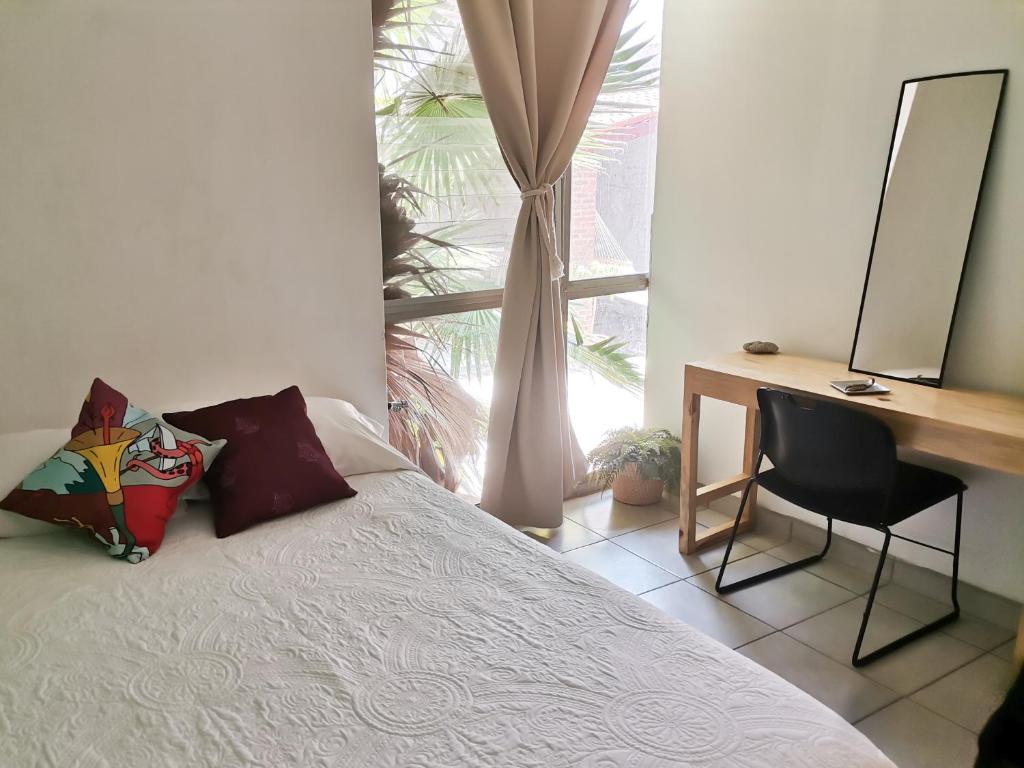 a bedroom with a bed and a desk and a window at Casa Matia in Guadalajara